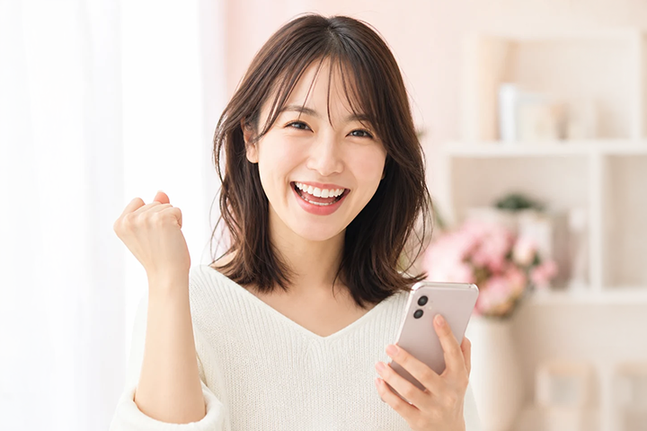 スマートフォンで報酬を確認する成人女性